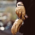 a person wearing a pair of yellow gloves