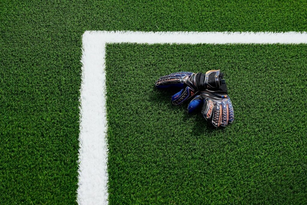 Current image: a soccer goalie's glove laying on a soccer field